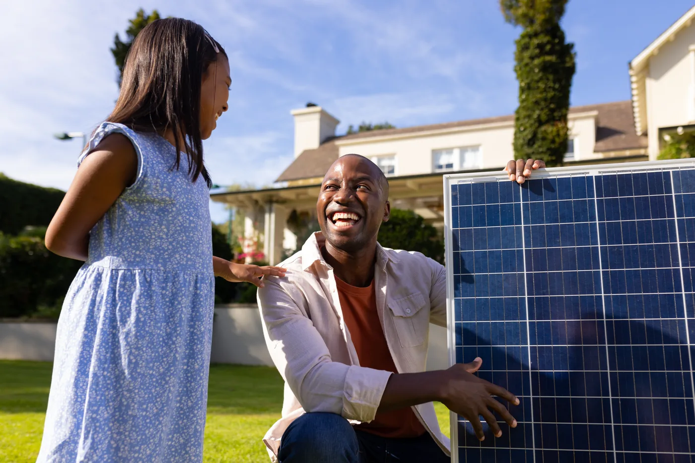 A father and daughter looking at a solar panel in their garden